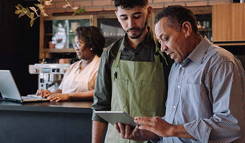 small business owner looking at tablet with employee