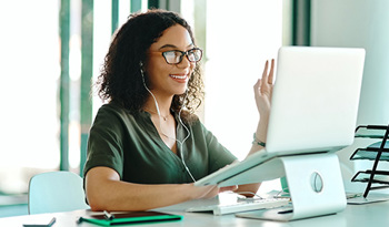 student attending online class in front of laptop